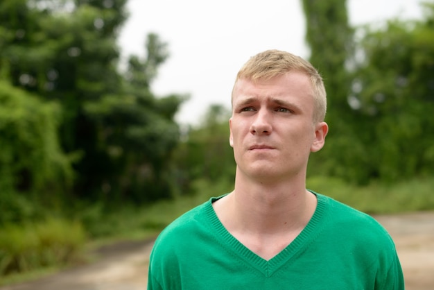 Portrait of young man with blond hair in the streets outdoors