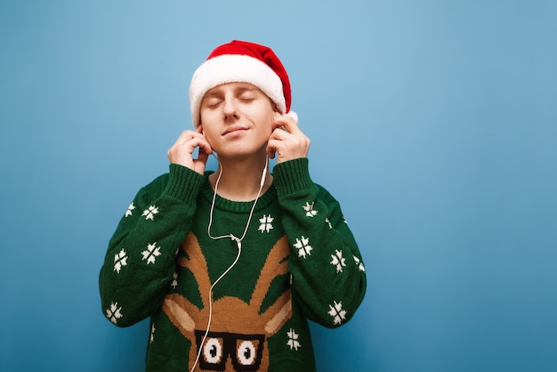 音楽を聴くクリスマスの肖像画の若い男