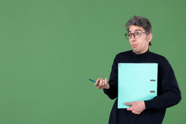 portrait of young man with file looking shocked on green background lesson teacher business