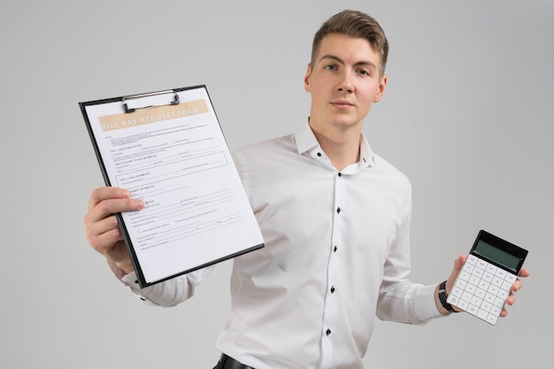 Portrait of young man with form of payment of bills and calculator in his hands isolated on white 