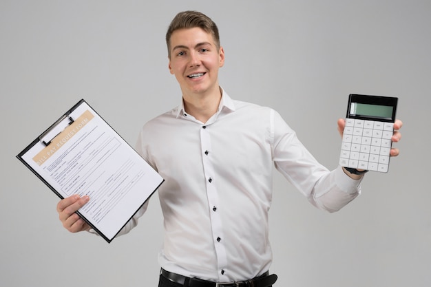 Portrait of young man with form of payment of bills and calculator in his hands isolated  