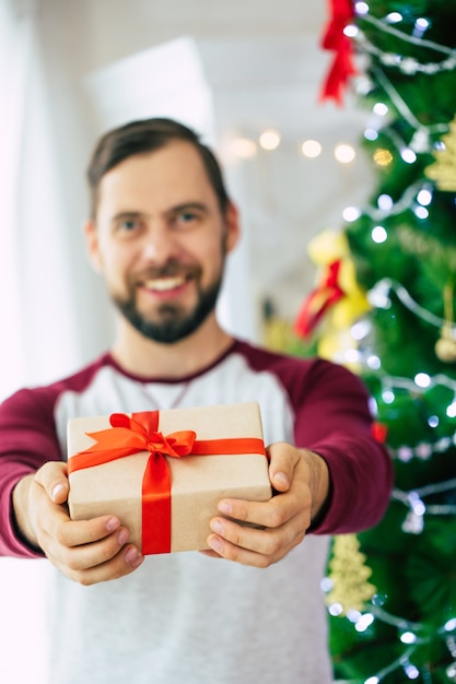 portrait young man with gift box at home on Christmas time