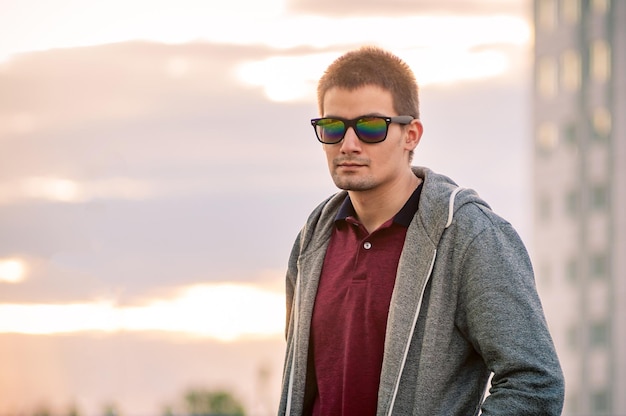 Portrait of a young man with glasses on the street