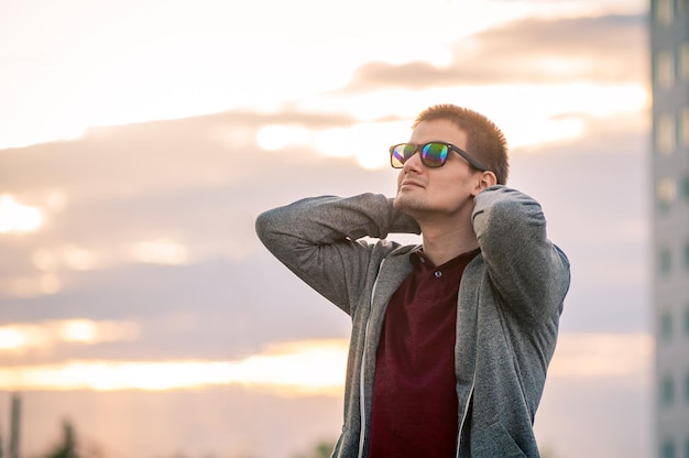 Portrait of a young man with glasses on the street