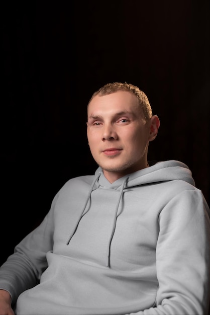 Portrait of a young man with a mutilated eye Dark background A young man looks into the camera Eye injury recovery after surgery