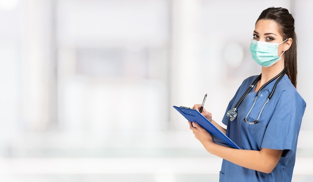 Portrait of a young masked nurse in an hospital