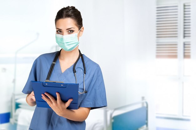 Portrait of a young masked nurse in an hospital