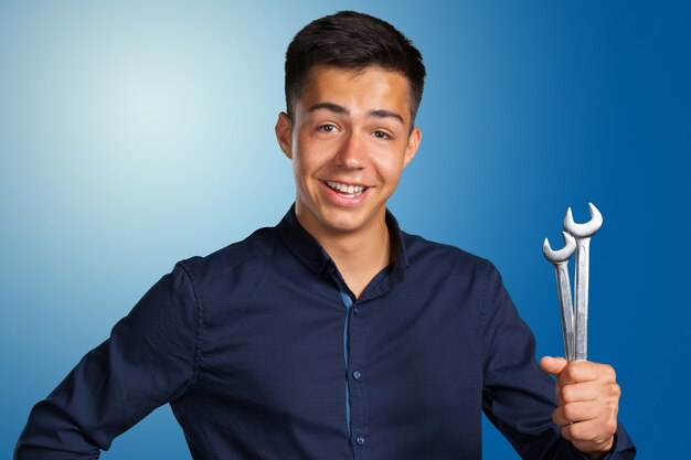 Portrait of a young mechanic holding a wrench 