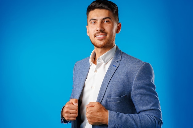 Portrait of a young mixed race businessman against blue background