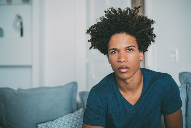 Portrait of a young mixed race man sitting in the sofa