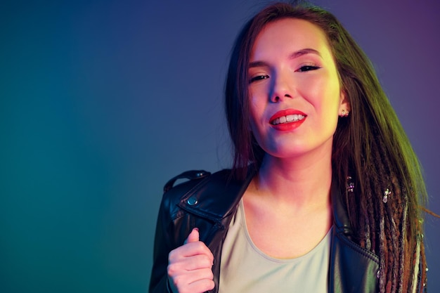 Portrait of a young mixed raced girl with braids against dark blue background