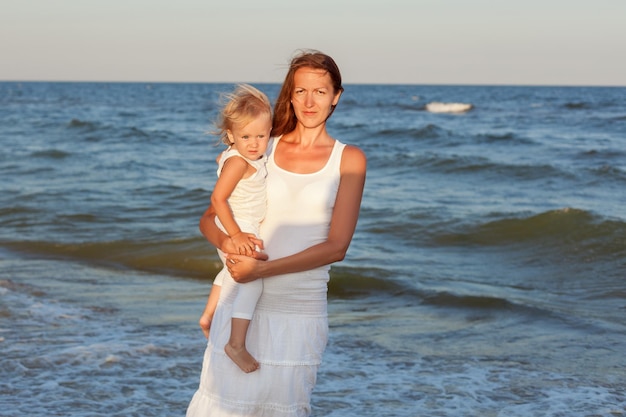 Portrait of a young mother and daughter on the seashore