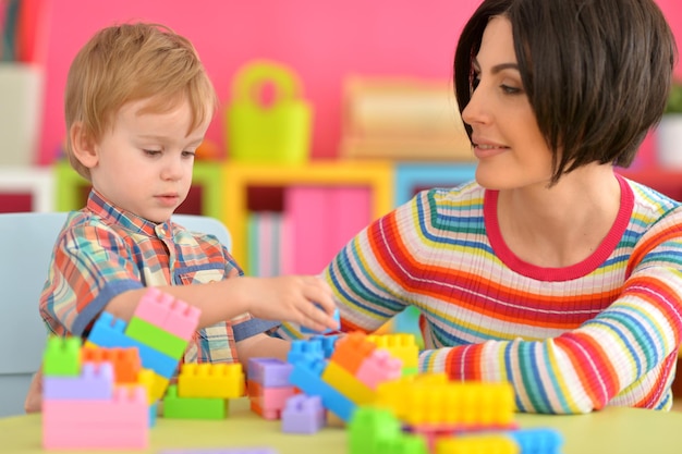 Portrait of young mother playing with son