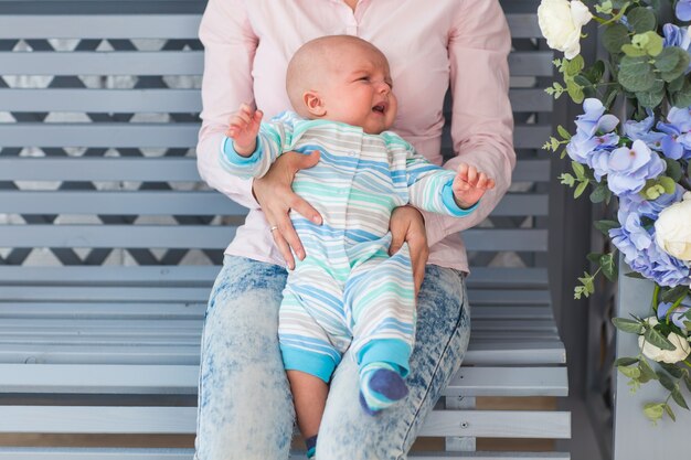 Ritratto di giovane madre con bambino carino a casa.