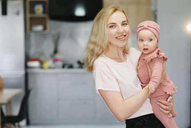 Portrait of young mother with cute baby at home