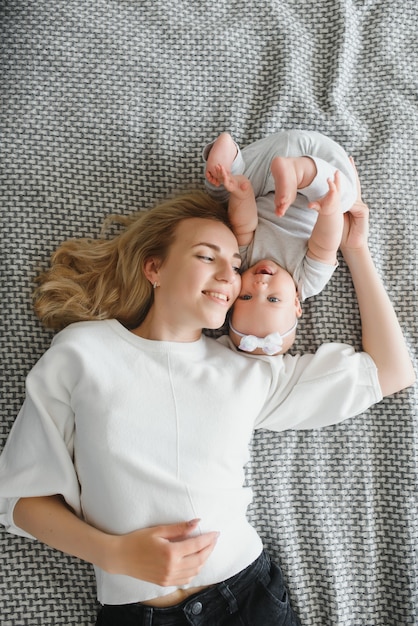 自宅でかわいい赤ちゃんと若い母親の肖像画