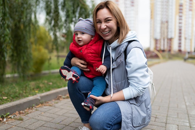 Portrait of a young mother woman with her oneyearold child in her arms against the backdrop of a