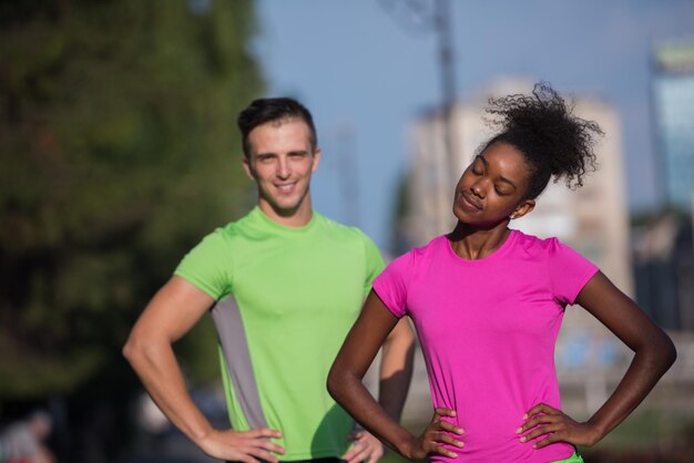 Foto ritratto di giovane coppia da jogging multietnica pronta a correre la mattina fresca in città
