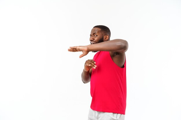 회색 배경 위에 격리된 채 옆을 바라보고 펀치를 날리며 서 있는 젊은 근육질의 아프리카계 미국인 남성 권투 선수의 초상화. 스포츠, 운동, 보디 빌딩.