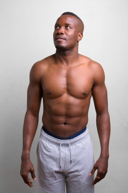 portrait of young muscular African man shirtless on white