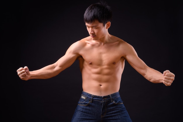 Portrait of young muscular Asian man shirtless ready to fight