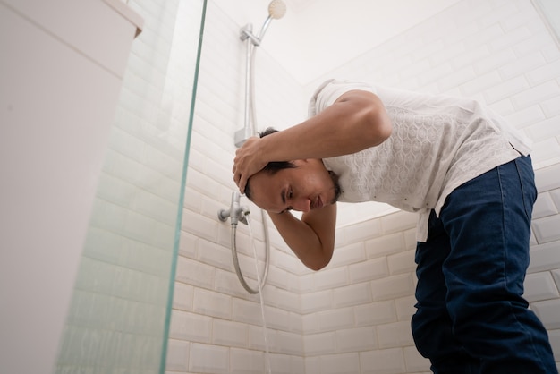 Portrait of young Muslim man perform ablution (wudhu) before prayer at home