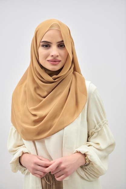 Portrait of young muslim woman wearing hijab on isolated white background. Fashionable and modern Islamic dress