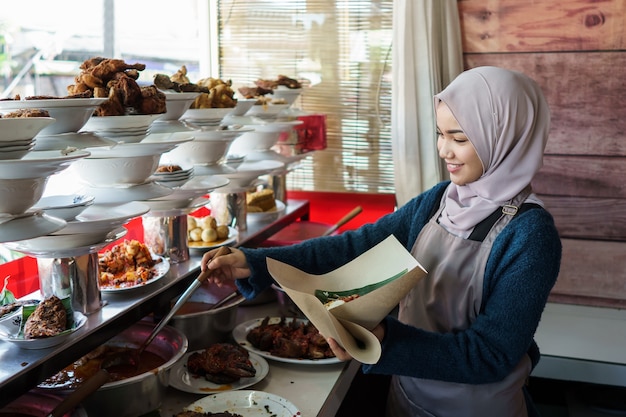 Portrait of young Muslim woman working in a restaurant