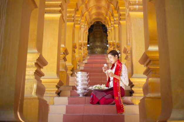 Portrait of a young Myanmar woman in a traditional welcoming dress and gesture