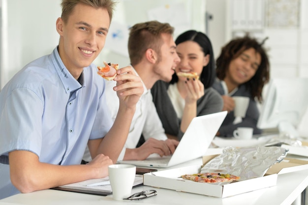 Portrait of a young people on break eating pizza