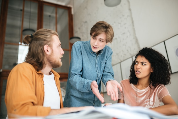 Portrait of young people emotionally discussing something in office