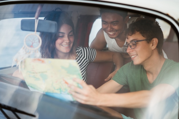 portrait of young people inside car using a map