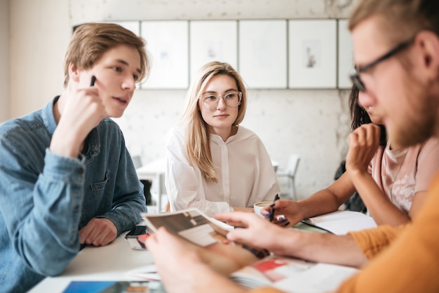 Portrait of young people thoughtfully discussing journals