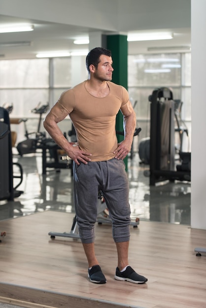 Portrait of a Young Physically Fit Man in Brown Tshirt Showing His Well Trained Body  Muscular Athletic Bodybuilder Fitness Model Posing After Exercises