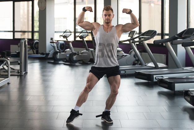 Portrait Of A Young Physically Fit Man In Undershirt Showing His Well Trained Body  Muscular Athletic Bodybuilder Fitness Model Posing After Exercises