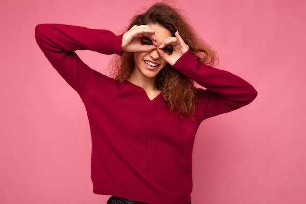 Portrait of young positive happy joyful beautiful brunette curly woman with sincere emotions wearing