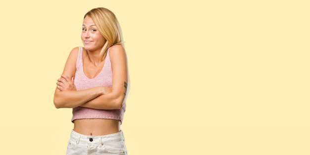 Portrait of young pretty blonde woman doubting and shrugging shoulders