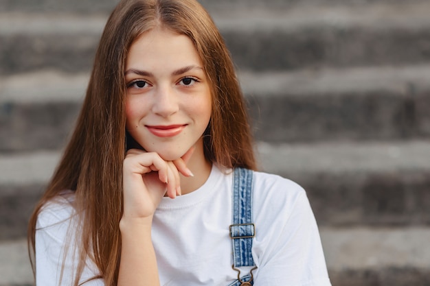 Portrait of young pretty girl sitting on stairs