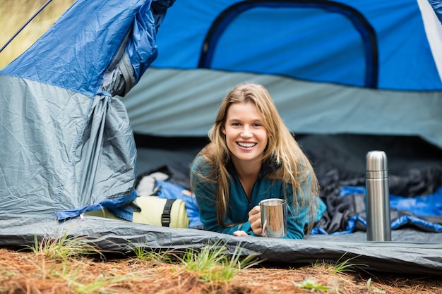 Portrait of a young pretty hiker lying in a tent