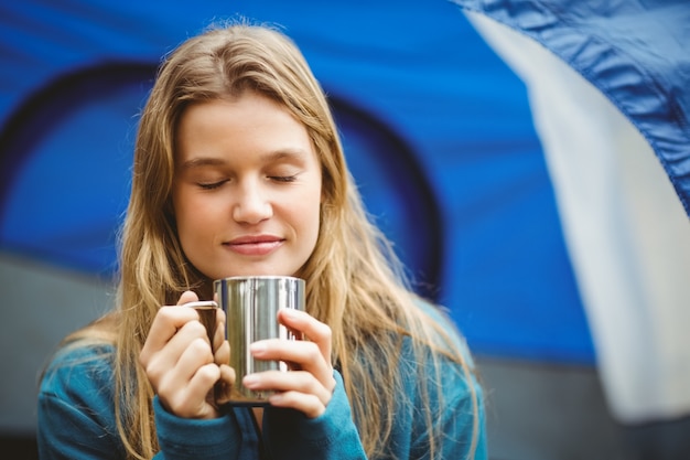 Portrait of a young pretty hiker sitting in a tent