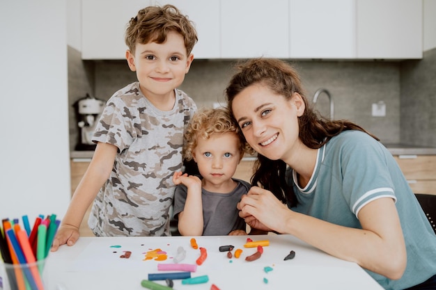 Portrait of young pretty mother is sitting at the kitchen table with her preschoolaged daughter