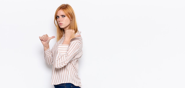 Photo portrait of a young pretty woman showing something