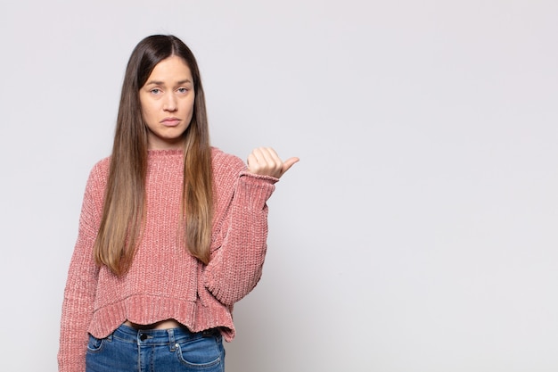 Portrait of a young pretty woman showing something