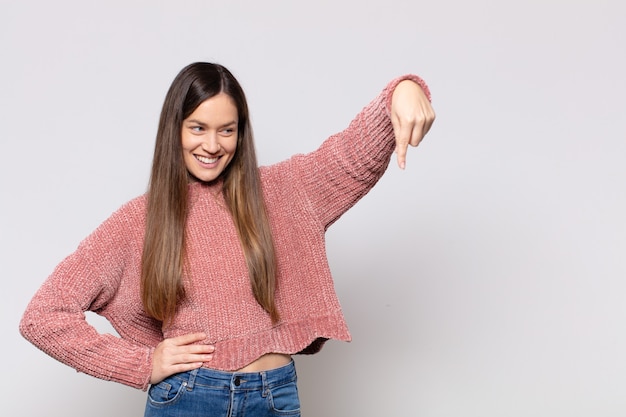 Foto ritratto di una giovane donna graziosa che mostra qualcosa