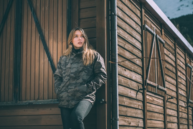 Portrait Young pretty woman in winter in a log cabin in the snow