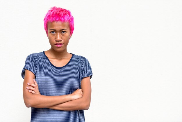 Photo portrait of young rebellious asian woman with pink hair against white space