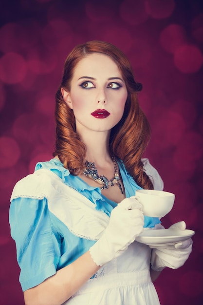 비디오 게임 이상한 나라의 앨리스로 분장한 젊은 빨간 머리 여성의 초상화.