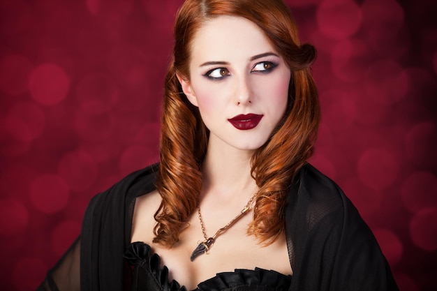 Портрет молодой рыжеволосой женщины, одетой как ведьма