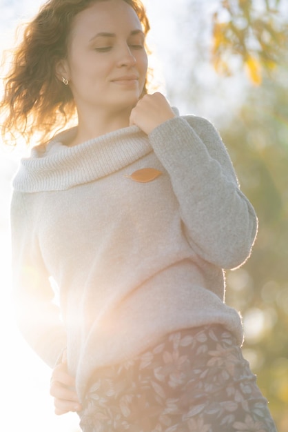 Portrait of young redhead woman looking down on the background of yellow leaves Closeup portrait