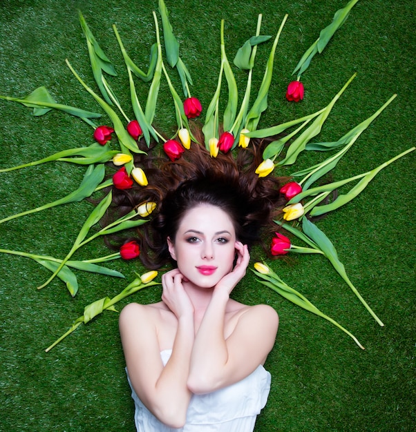 Portrait of a young redhead woman with tulips